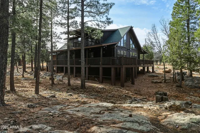 a view of a house with a large tree and a yard