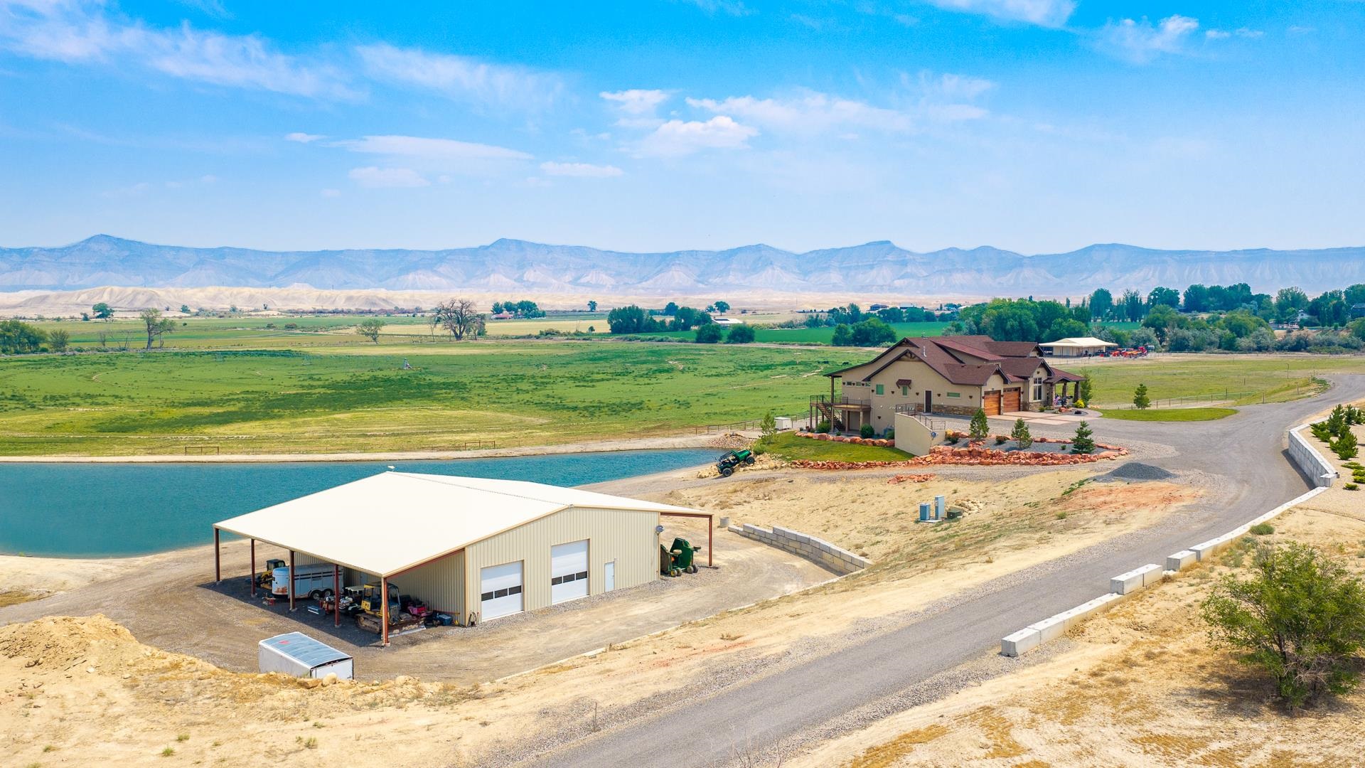 2440 J Road Grand Junction, CO 81505 - Photo 4 of 42 a view of a house with a yard and a mountain view in back