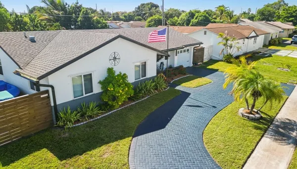 a aerial view of a house with swimming pool and next to a yard
