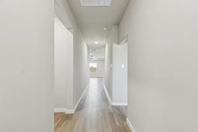 a view of a hallway with wooden floor