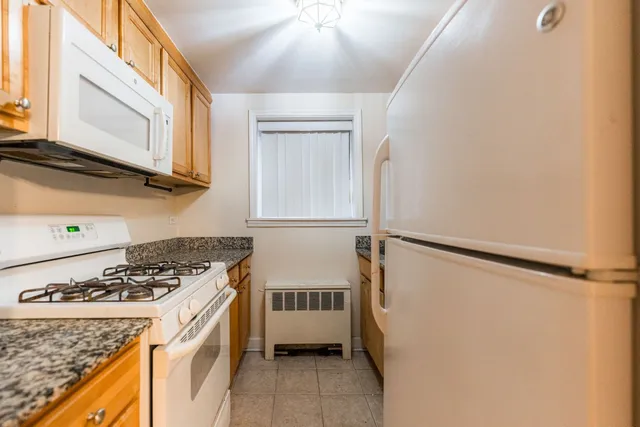 a kitchen with a stove a refrigerator and cabinets