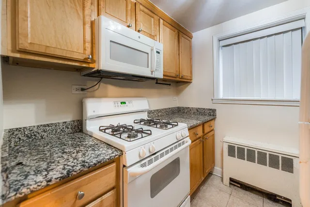 a kitchen with white cabinets and appliances