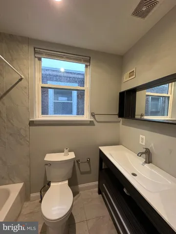 a bathroom with a toilet a sink and mirror