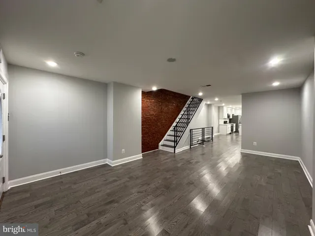 an empty room with wooden floor and stairs