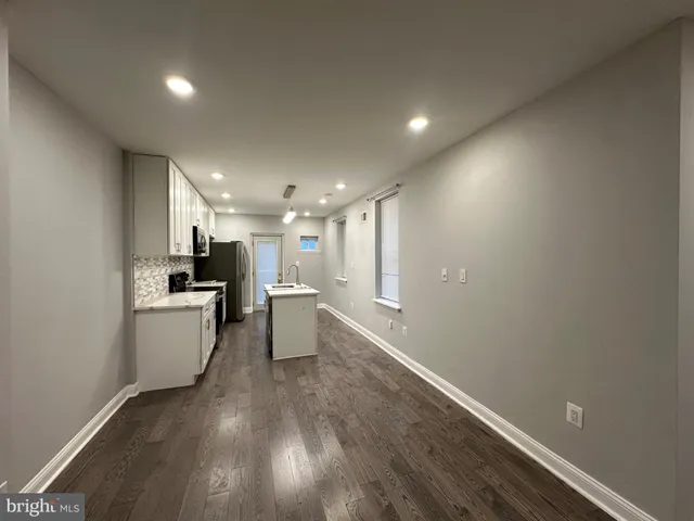 a view of a kitchen with a sink and a refrigerator
