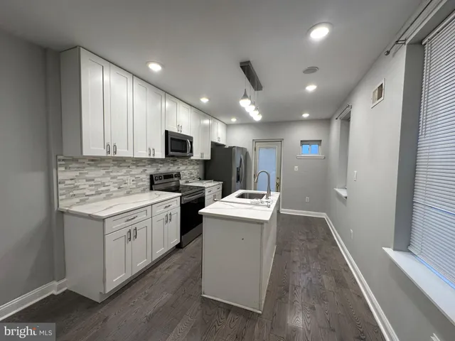 a kitchen with stove a sink and refrigerator