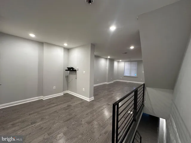 an empty room with wooden floor and staircase