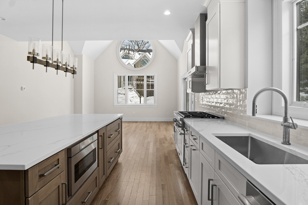 a kitchen with stainless steel appliances granite countertop a sink stove and cabinets