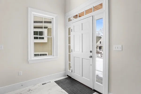 an entryway to room with wooden floor and windows