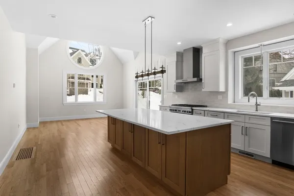 a kitchen with stainless steel appliances granite countertop a sink stove and wooden floor