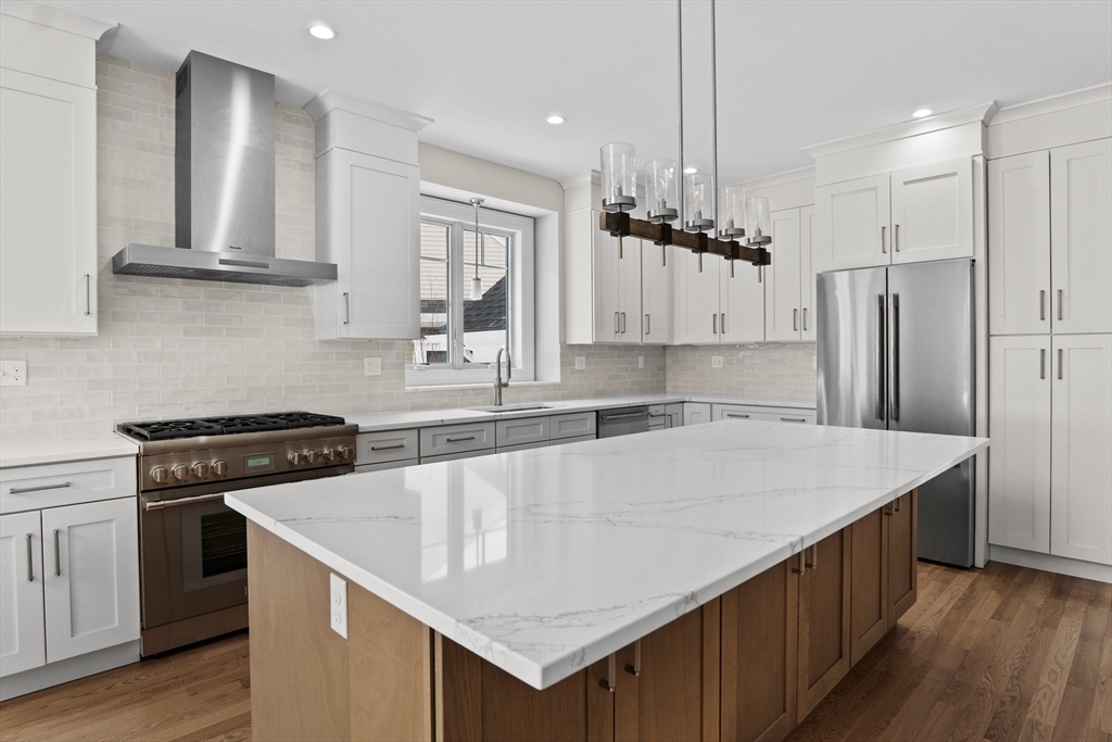 17 Courtyard Place, Unit 17 Reading, MA 01867 - Photo 6 of 12 a kitchen with a stove a sink and a refrigerator