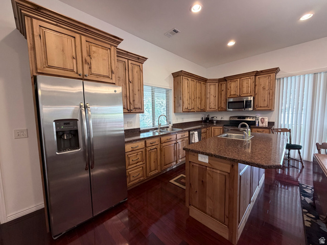 2855 South 1000 West Perry, UT 84302 - Photo 109 of 142 Kitchen with stainless steel appliances, a center island with sink, a kitchen bar, dark wood-style floors, and recessed lighting