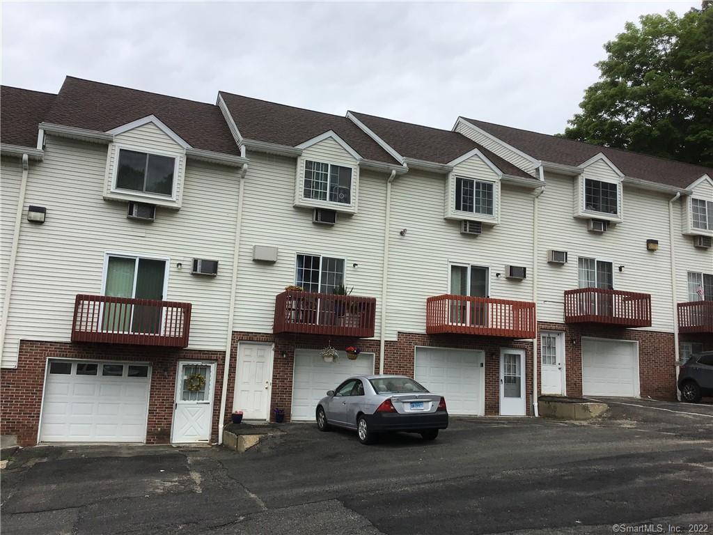 66 Wakelee Road, Unit 4 Waterbury, CT 06705 - Photo 1 of 1 a car parked in front of a white building