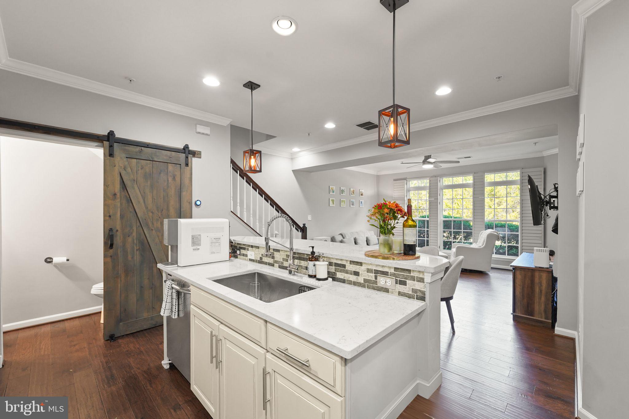 43846 Artsmith Terrace Ashburn, VA 20147 - Photo 13 of 38 a view of a kitchen with kitchen island a stove a refrigerator a sink dishwasher with a dining table and chairs with wooden floor