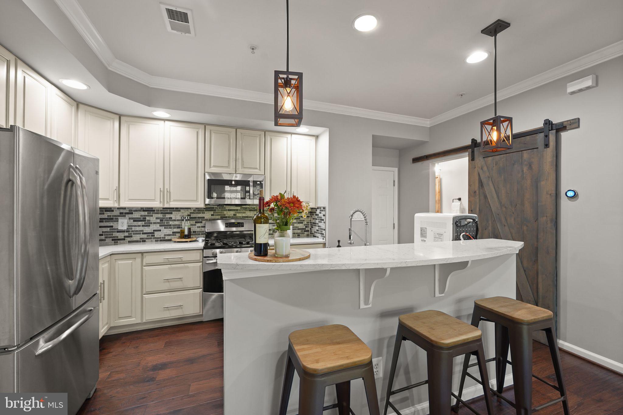 43846 Artsmith Terrace Ashburn, VA 20147 - Photo 9 of 38 a kitchen with refrigerator a sink and chairs