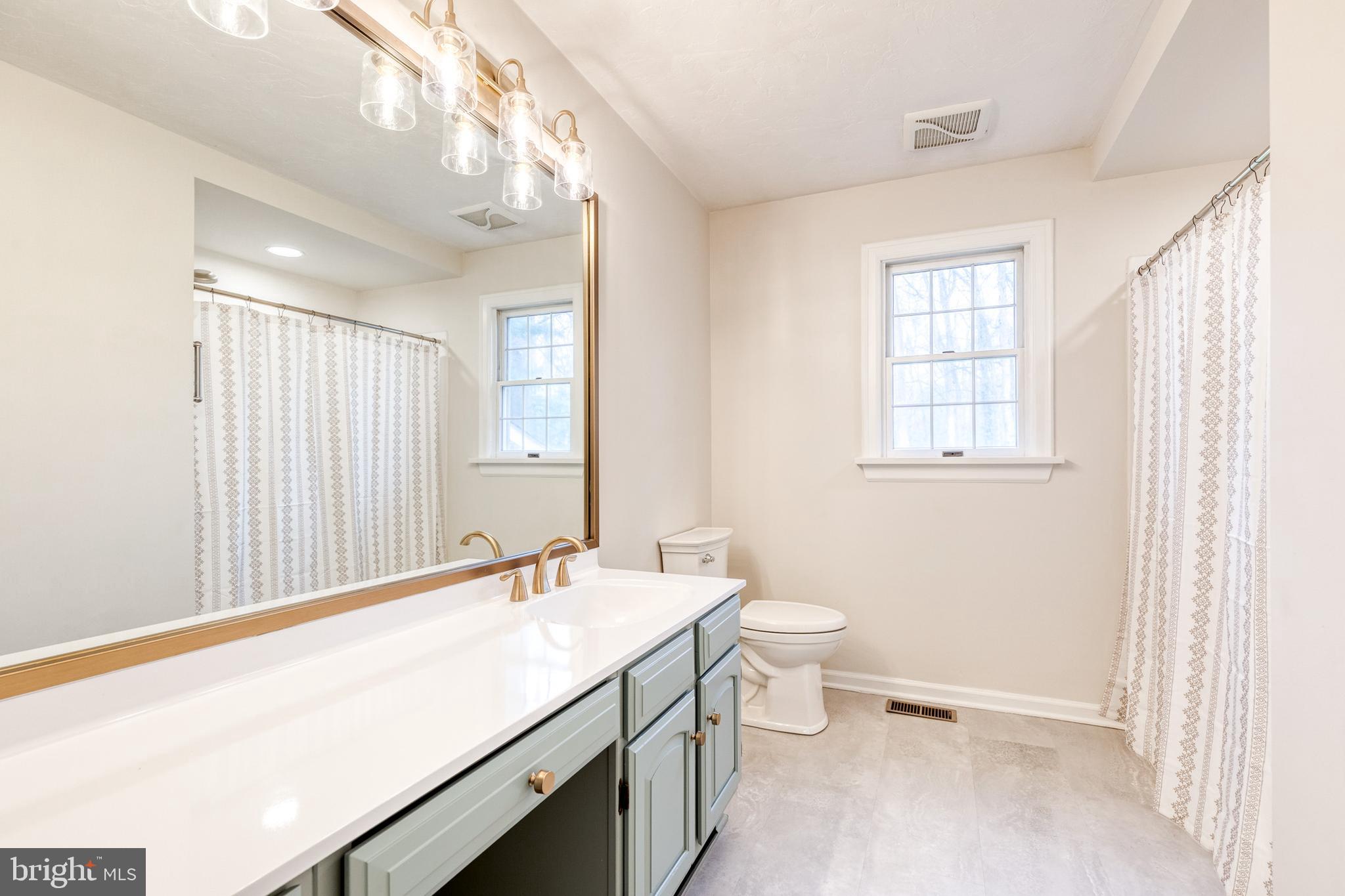 1216 Bonaire Road Forest Hill, MD 21050 - Photo 32 of 71 a bathroom with a granite countertop sink a toilet and a window