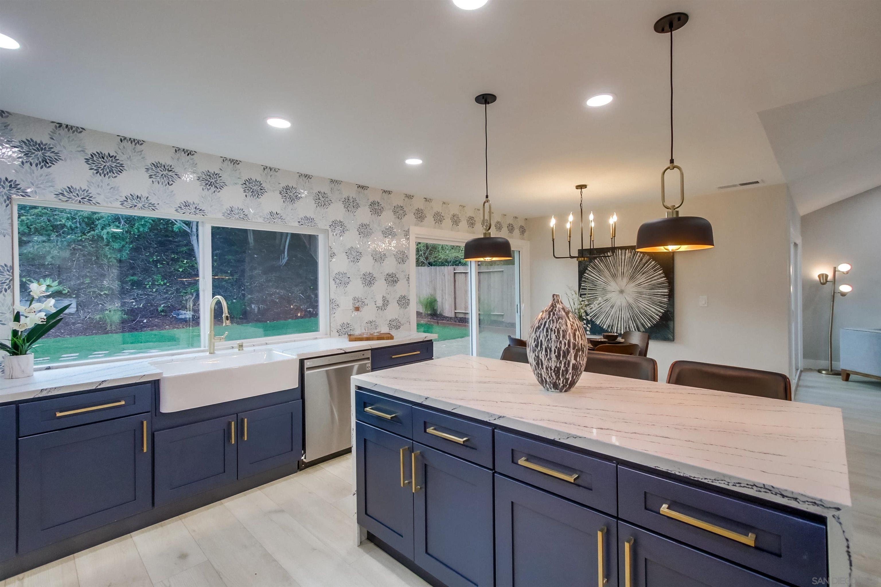 a kitchen with kitchen island granite countertop a sink and a stove