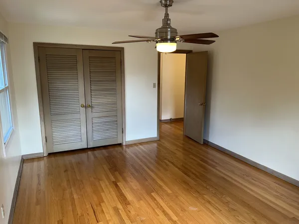 a view of empty room with wooden floor