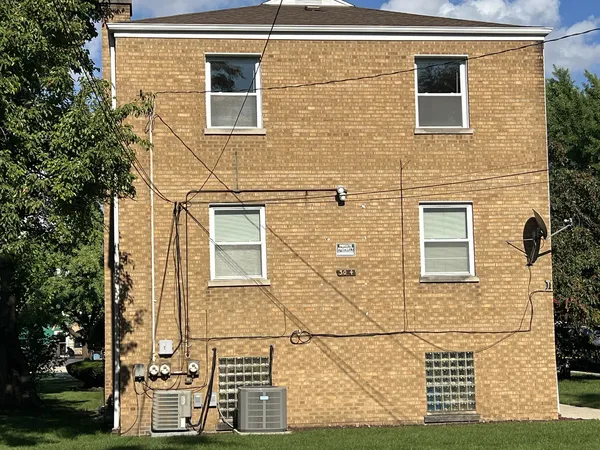 front view of a brick house with a small yard