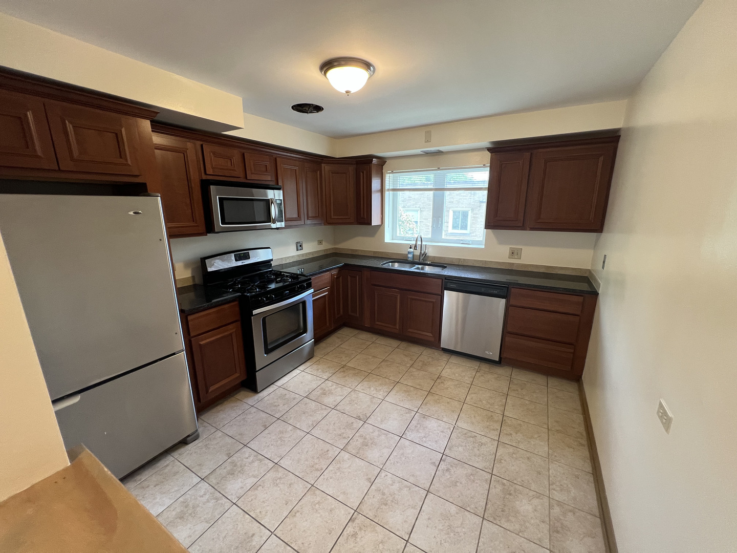 3014 Harlem Avenue, Unit 1 Riverside, IL 60546 - Photo 9 of 22 a kitchen with stainless steel appliances granite countertop a stove top oven a sink dishwasher and a refrigerator with wooden cabinets