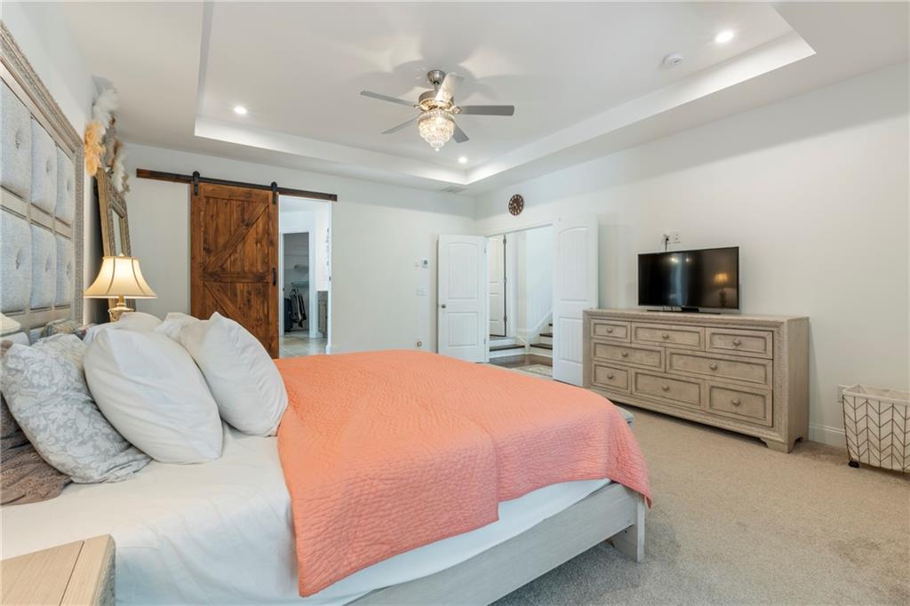 8110 Scenic Ridge Way Ball Ground, GA 30107 - Photo 13 of 29 a bedroom with a bed a dresser and a flat screen tv