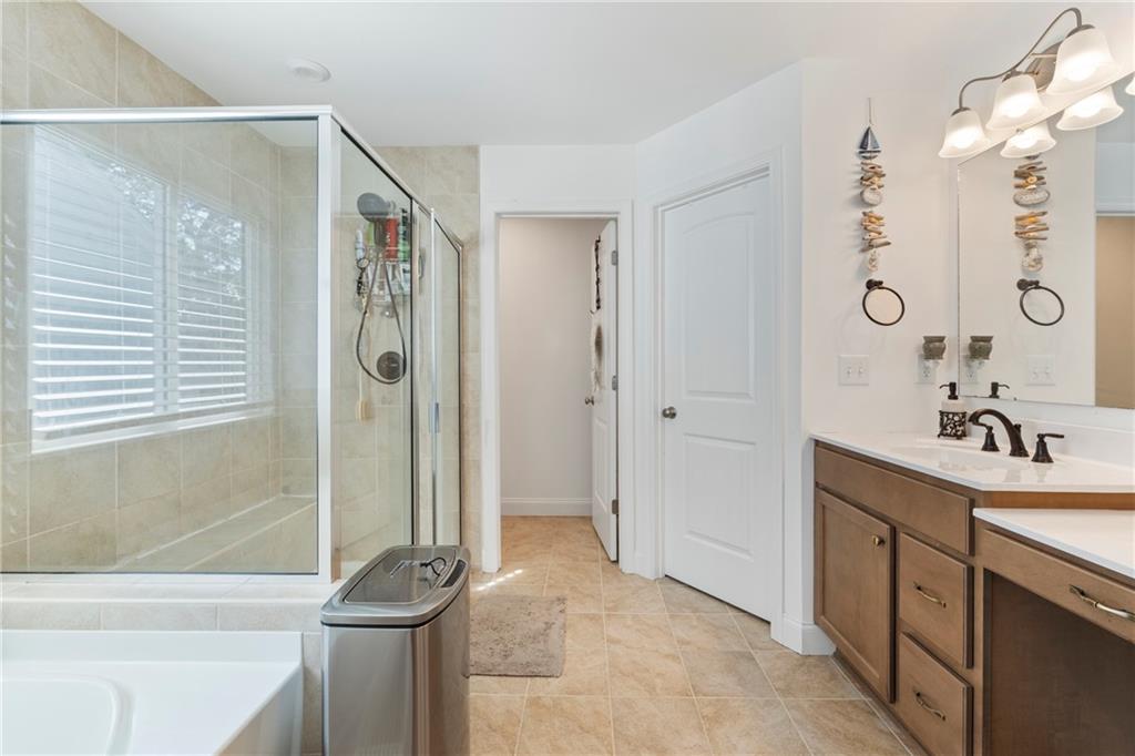 8110 Scenic Ridge Way Ball Ground, GA 30107 - Photo 14 of 29 a bathroom with a tub sink and mirror