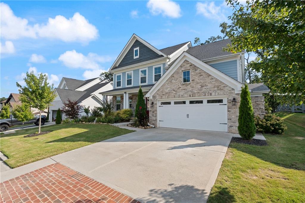 8110 Scenic Ridge Way Ball Ground, GA 30107 - Photo 24 of 29 a front view of a house with a yard and garage