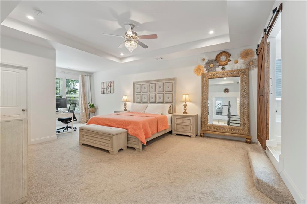 8110 Scenic Ridge Way Ball Ground, GA 30107 - Photo 4 of 29 a spacious bedroom with a bed a dresser and windows