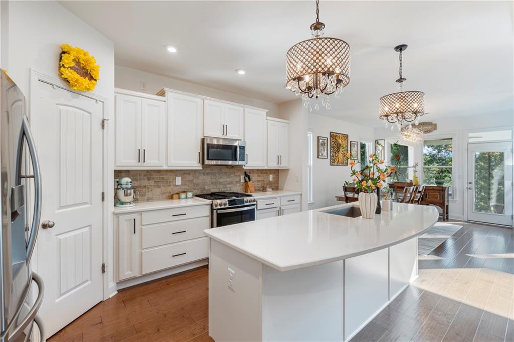 8110 Scenic Ridge Way Ball Ground, GA 30107 - Photo 8 of 29 a kitchen with a sink stainless steel appliances and chandelier