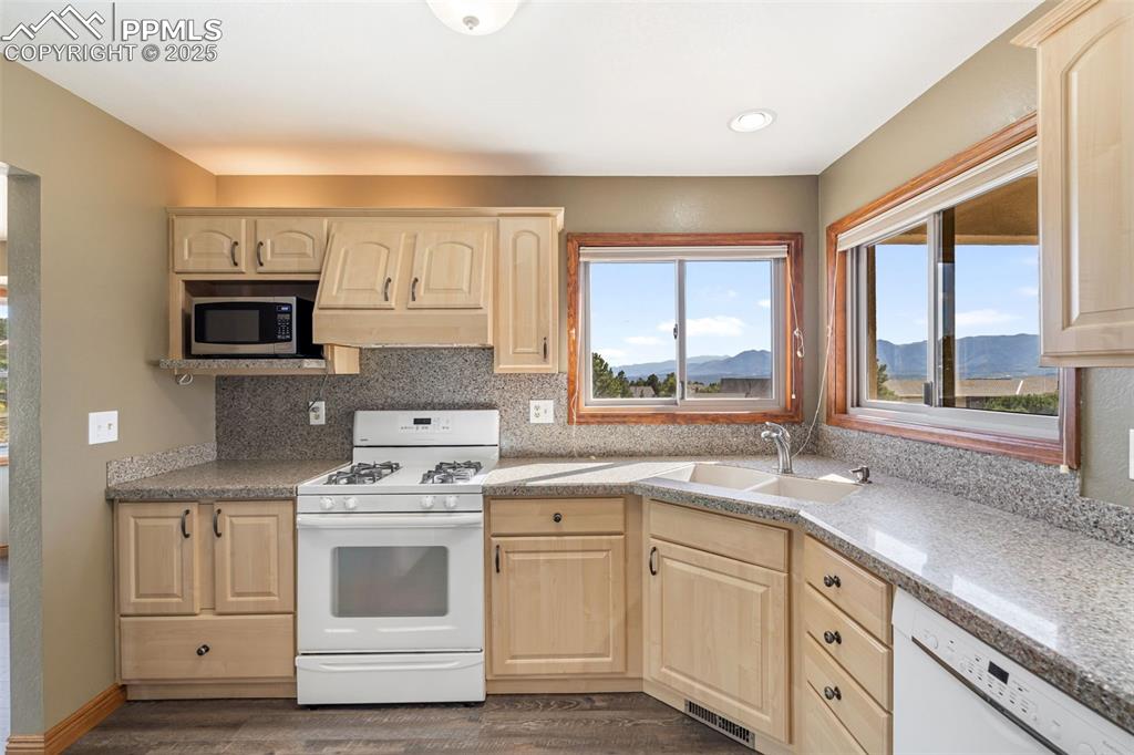 725 Bowstring Road Monument, CO 80132 - Photo 11 of 50 a kitchen with cabinets appliances a sink and a window