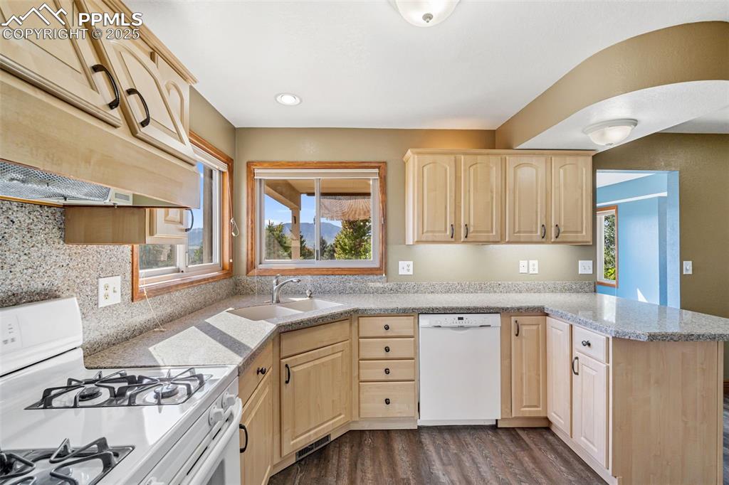 725 Bowstring Road Monument, CO 80132 - Photo 12 of 50 a kitchen with a stove a sink and wooden floor