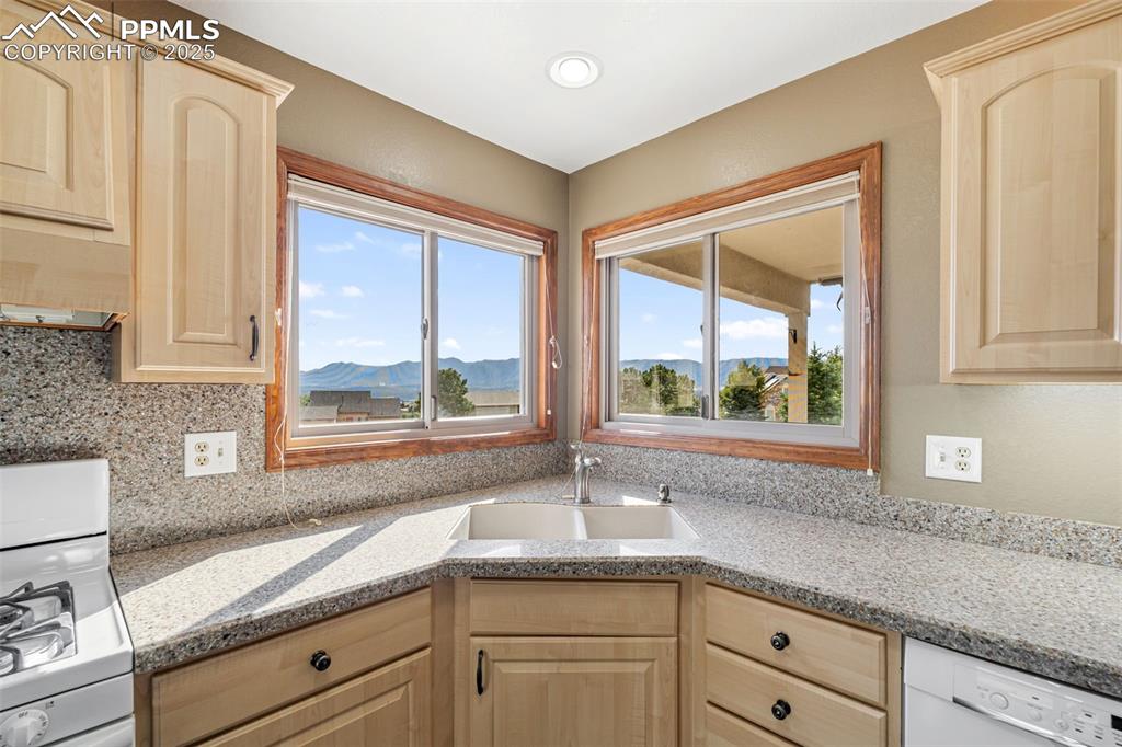725 Bowstring Road Monument, CO 80132 - Photo 13 of 50 a kitchen with granite countertop white cabinets and a window