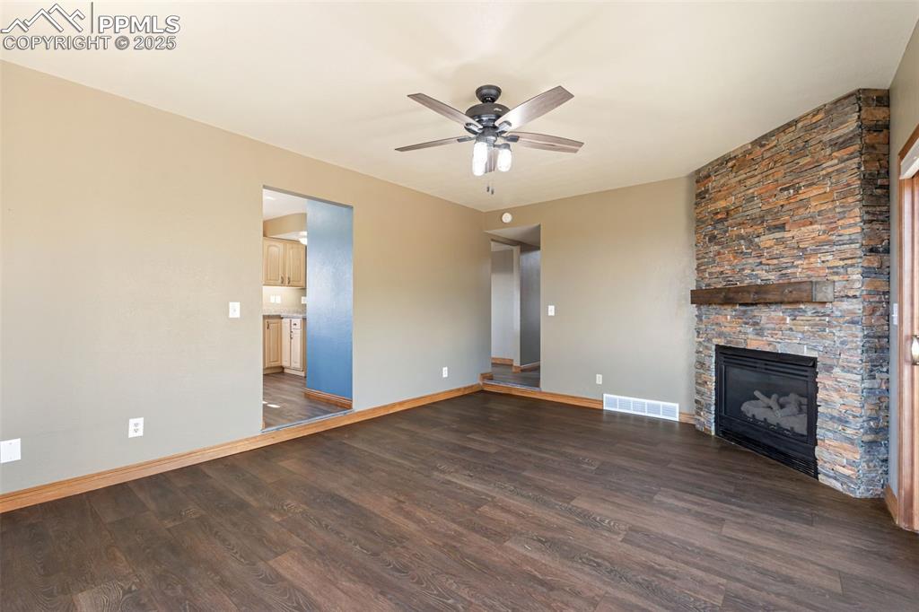 725 Bowstring Road Monument, CO 80132 - Photo 16 of 50 a view of an empty room with wooden floor and a fireplace