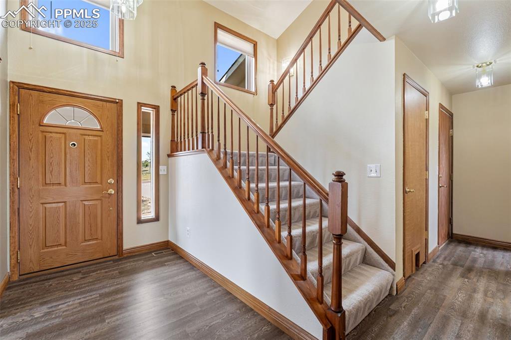 725 Bowstring Road Monument, CO 80132 - Photo 19 of 50 a view of front door with wooden floor and stairs