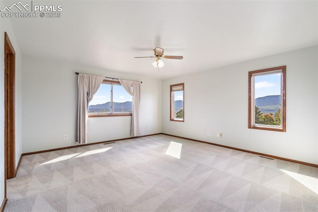 725 Bowstring Road Monument, CO 80132 - Photo 30 of 50 an empty room with chandelier fan and windows