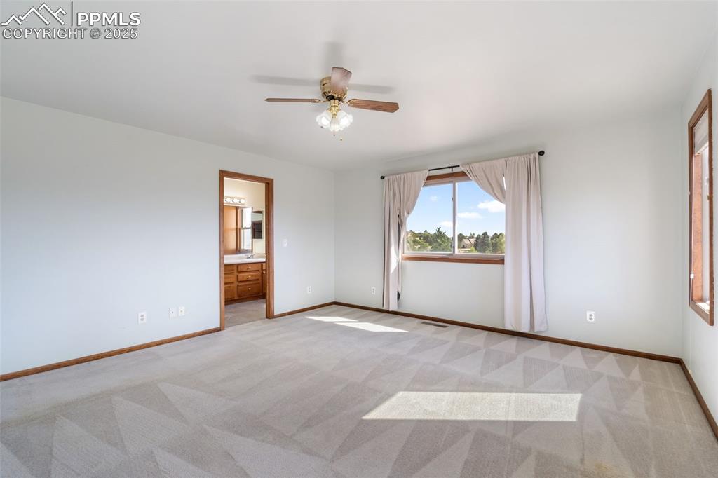 725 Bowstring Road Monument, CO 80132 - Photo 32 of 50 an empty room with chandelier fan and windows