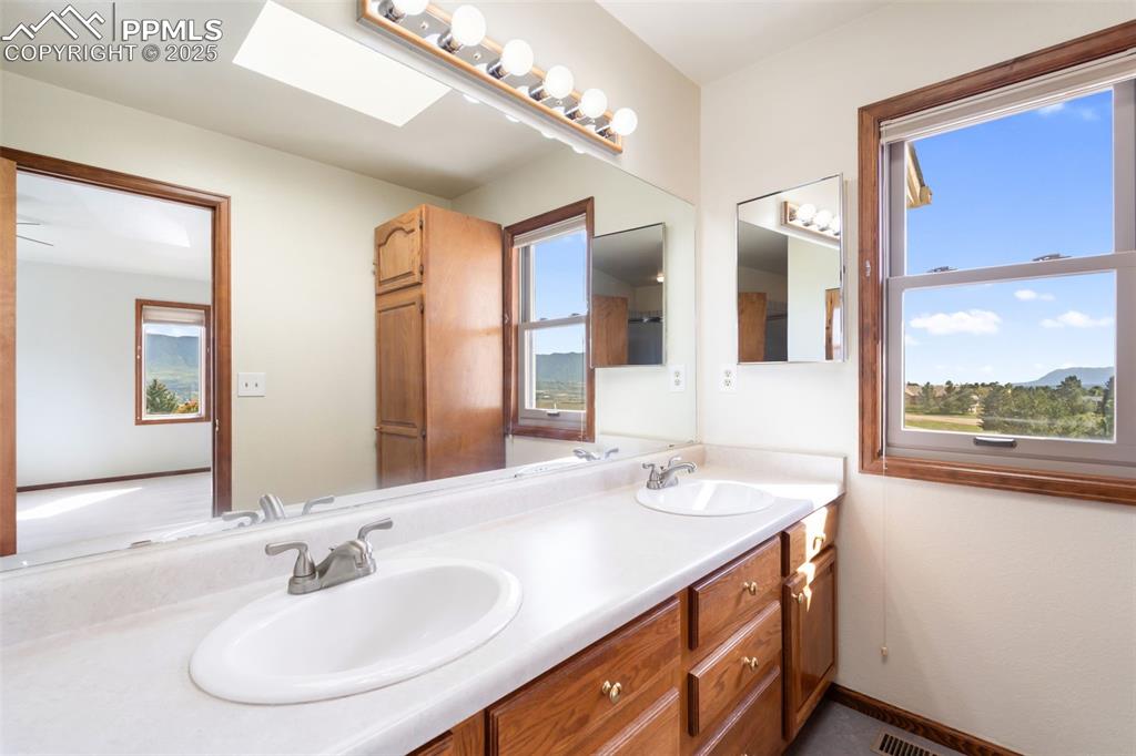 725 Bowstring Road Monument, CO 80132 - Photo 34 of 50 a bathroom with a double vanity sink and a mirror