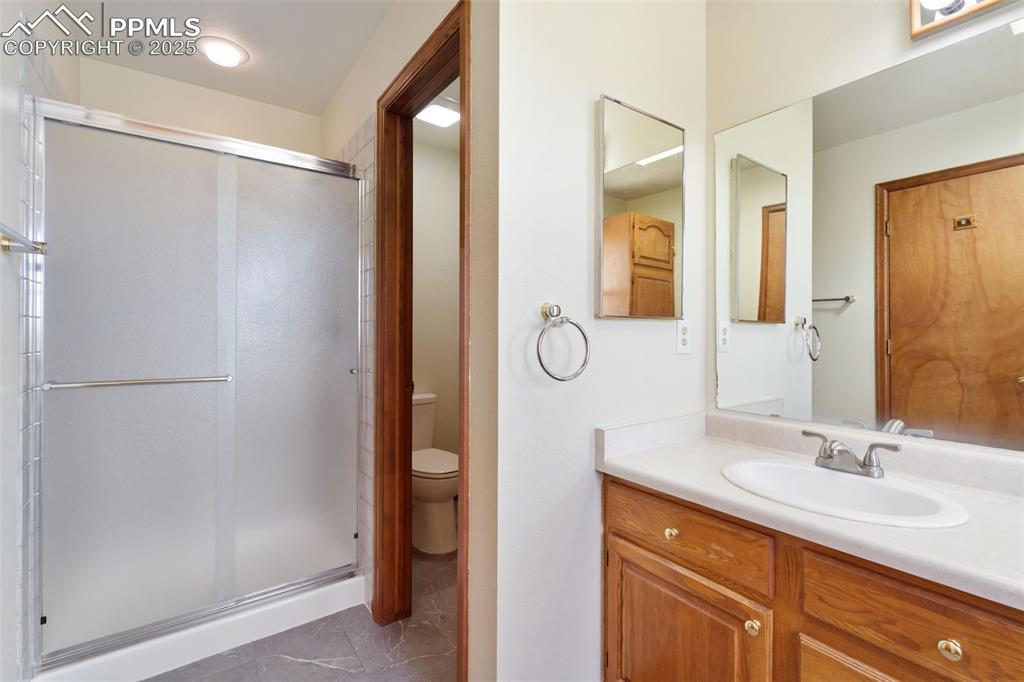 725 Bowstring Road Monument, CO 80132 - Photo 35 of 50 a bathroom with a double vanity sink mirror and shower