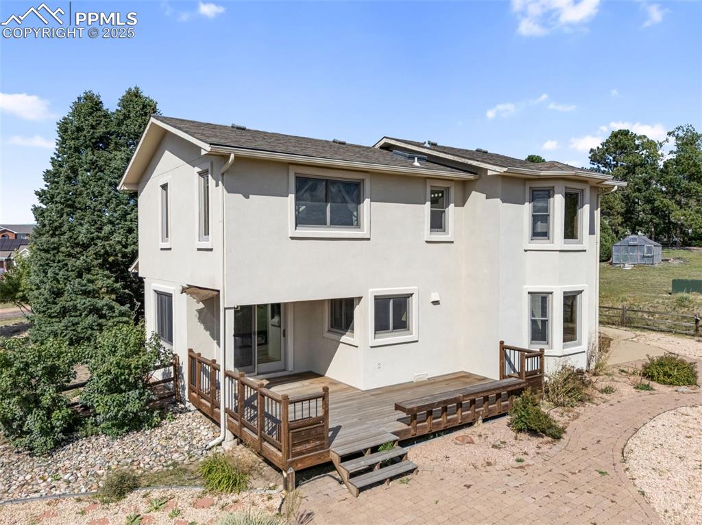 725 Bowstring Road Monument, CO 80132 - Photo 46 of 50 a view of a white house with a yard and balcony