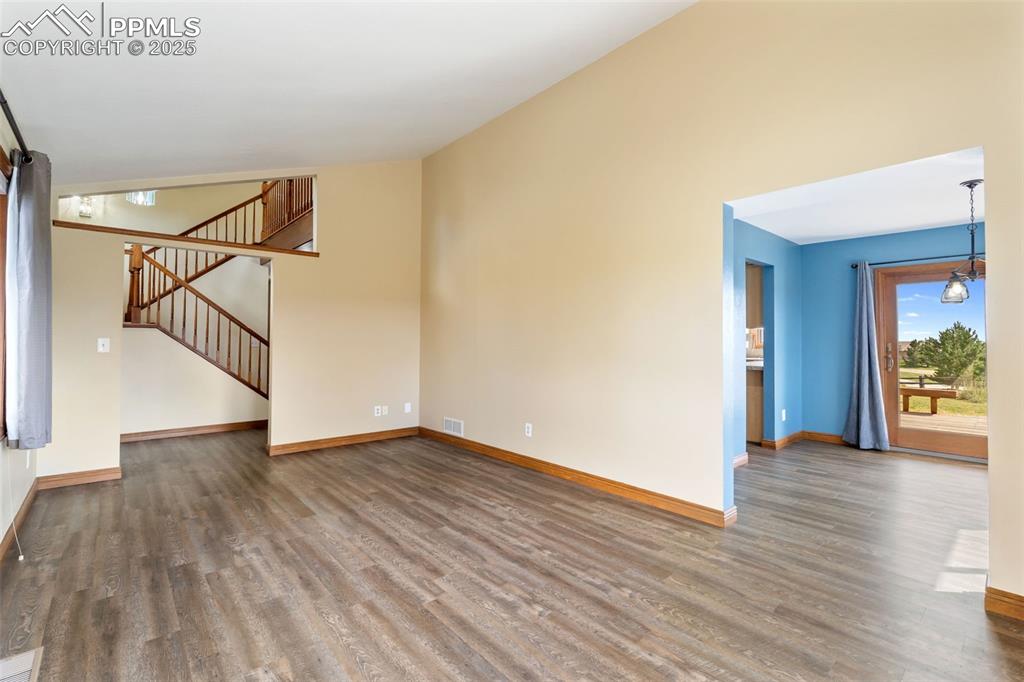 725 Bowstring Road Monument, CO 80132 - Photo 5 of 50 a view of an empty room with wooden floor and a potted plant