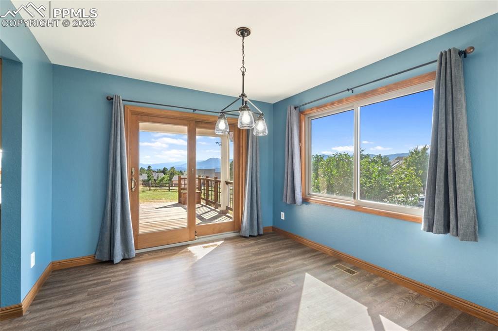 725 Bowstring Road Monument, CO 80132 - Photo 6 of 50 a view of empty room with wooden floor and windows