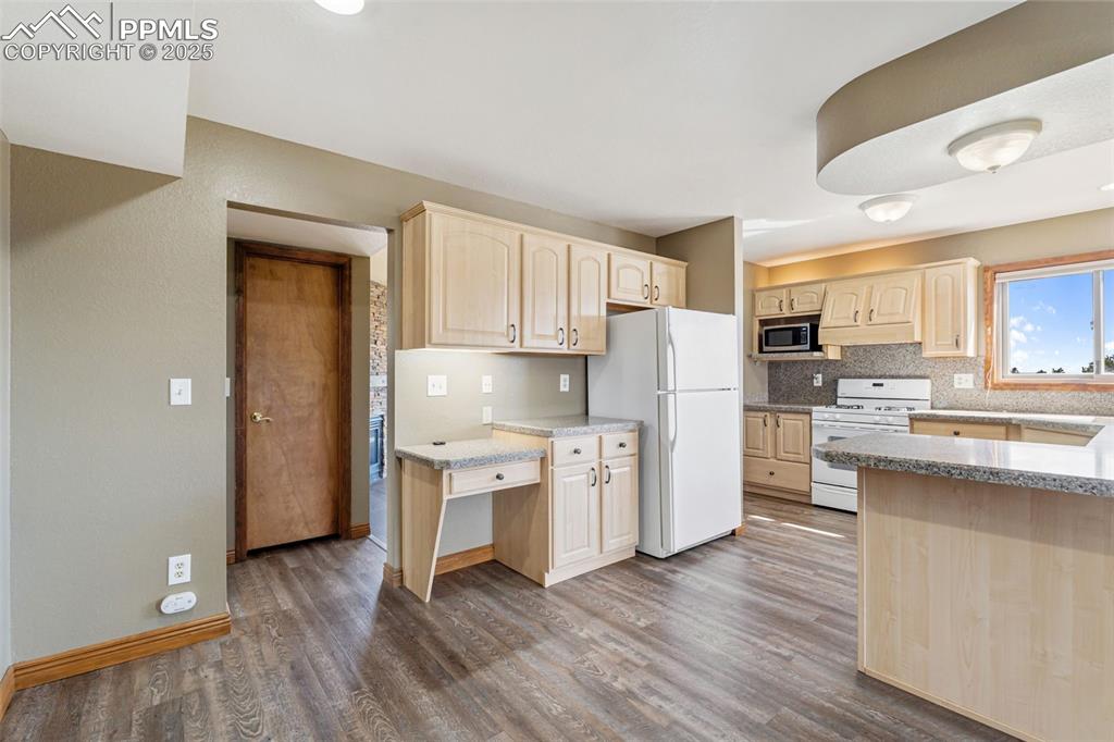 725 Bowstring Road Monument, CO 80132 - Photo 8 of 50 a kitchen with white cabinets and stainless steel appliances