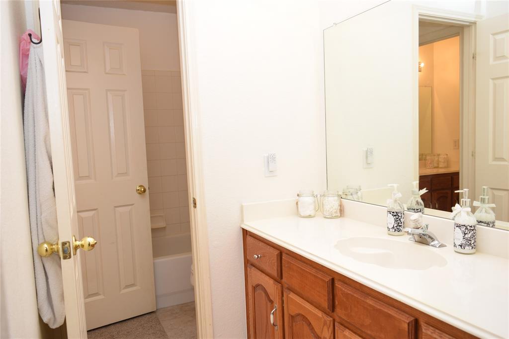 4201 Glistening Spring Rowlett, TX 75088 - Photo 23 of 33 Jack & Jill Bathroom vanity featuring a single basin, laminate countertop, and wood-finish cabinetry