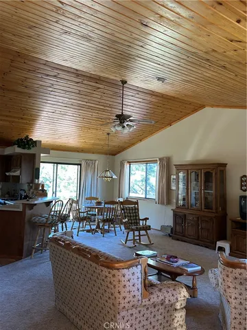 a living room with furniture kitchen view and a large window