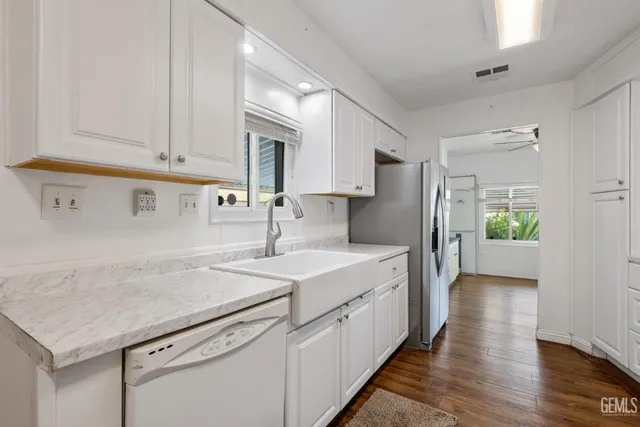 a kitchen with stainless steel appliances a sink dishwasher stove refrigerator and cabinets