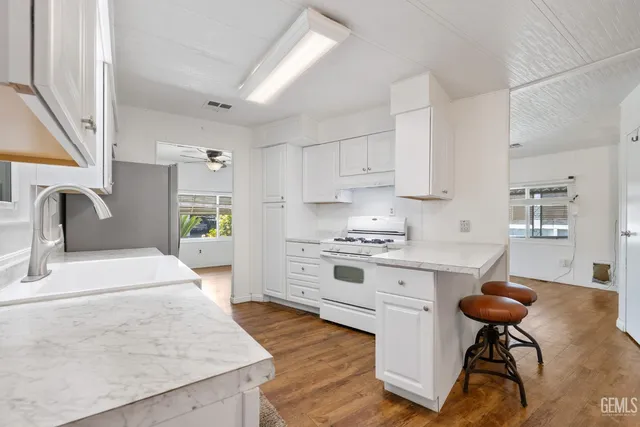 a kitchen with stainless steel appliances granite countertop a stove a sink and a refrigerator