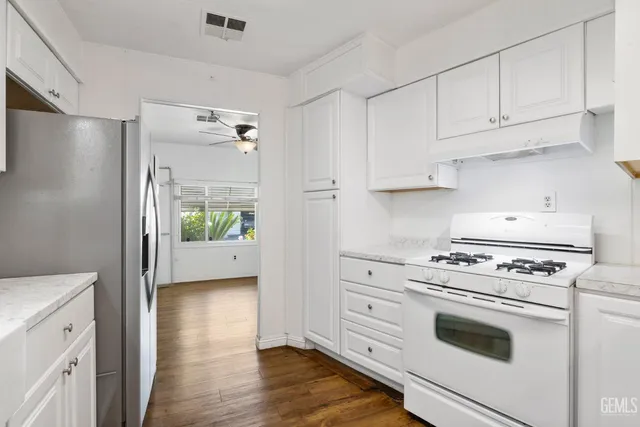 a kitchen with white cabinets and white appliances