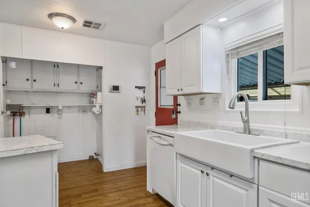 a kitchen with a sink cabinets stainless steel appliances and a window