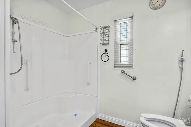 a bathroom with a shower a toilet and a shower