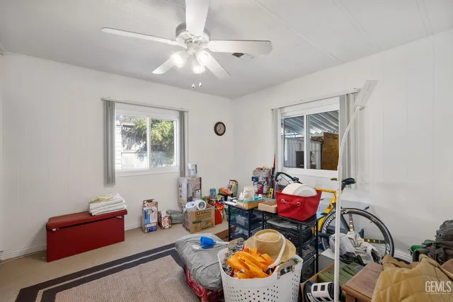 a living room with furniture a chandelier fan and a window